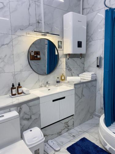 a white bathroom with a sink and a mirror at Studio MD in Chişinău
