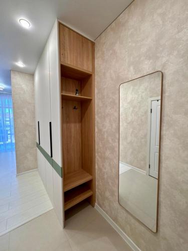 a dressing room with a mirror on the wall at A-Six Apartment, ЖК Достар 26 in Karagandy