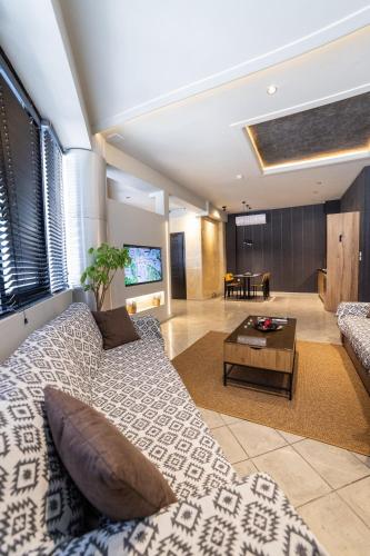 a living room with a couch and a table at Omega Suites 30 in Tríkala