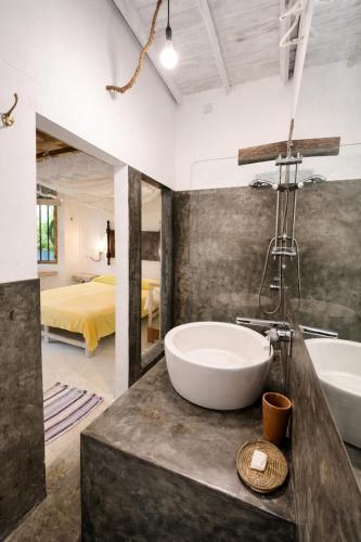 a bathroom with a tub and a sink and a bed at Deep Blue in Matara