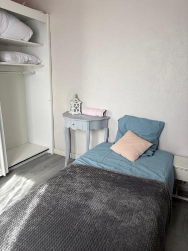 a small bedroom with a bed and a table at Chambre Maria in Le Pollet