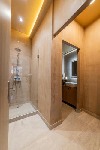 a large bathroom with a shower and a sink at Omega Suites 30 in Tríkala
