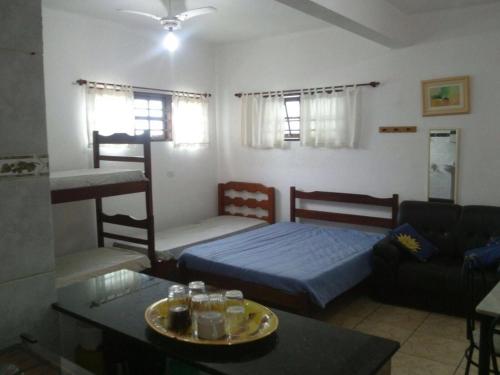 sala de estar con cama y sofá en Chales Ubatuba I, en Ubatuba