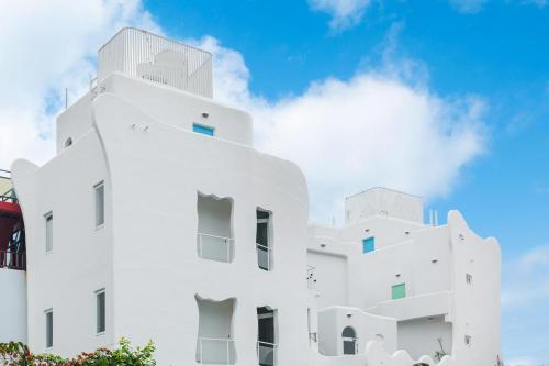 a white building with a blue sky in the background at Mare Cielo in Xiaoliuqiu