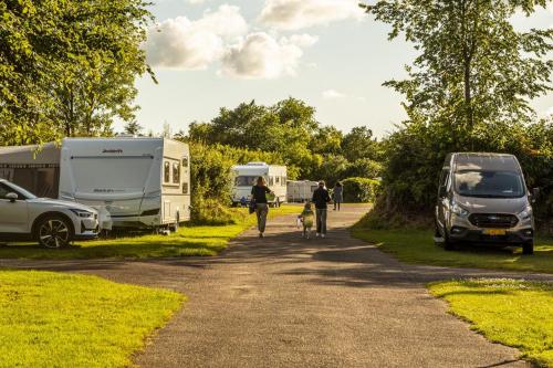 a person riding a bike down a dirt road next to tents at DCU-Camping Hesselhus in Silkeborg