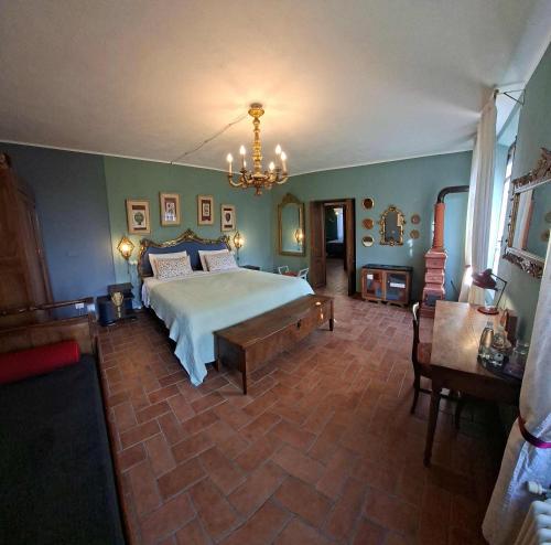 a bedroom with a large bed and a chandelier at B&B Podere Merlo in Parma