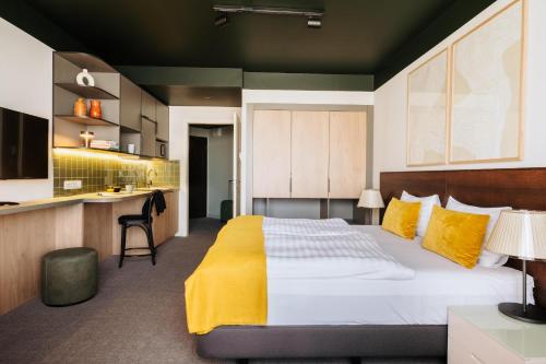 a bedroom with a large bed and a kitchen at Adina Apartment Hotel Budapest in Budapest