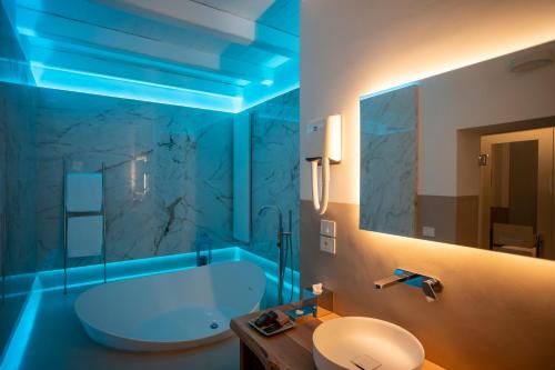a bathroom with a tub and a toilet and a sink at Rose Iconic Rooms in Lecce