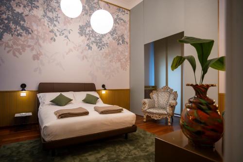 a bedroom with a bed and a vase with a plant at Rose Iconic Rooms in Lecce