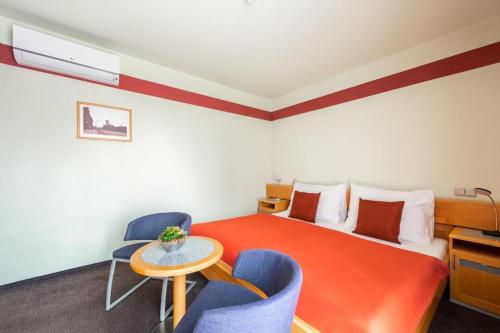 a hotel room with a bed and two chairs and a table at Jan Maria Hotel in Ostrava