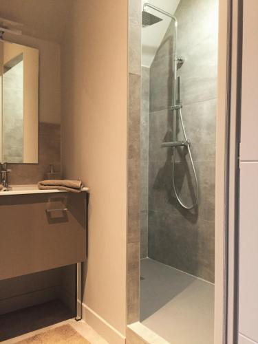 une douche avec une porte vitrée dans une salle de bain dans l'établissement Villa d'hôtes Graine de Pin, à Le Touquet-Paris-Plage