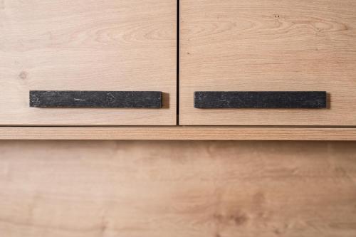 two black handles on a wooden cabinet drawer at Alpinliving.Tirol in Aschau
