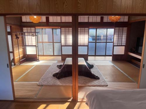 a room with a bed in a room with windows at 三重観光の拠点伊勢神宮鈴鹿サーキットアクセス良好家族グループ旅行なぎさの宿 in Tsu
