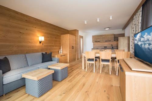a living room with a couch and a dining room at Alpinliving.Tirol in Aschau