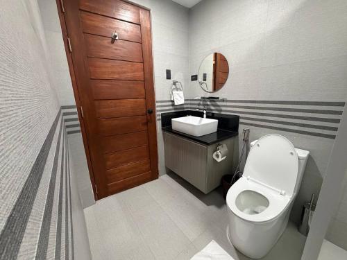 a small bathroom with a toilet and a sink at Apples&Pears Hotel in Manaoag