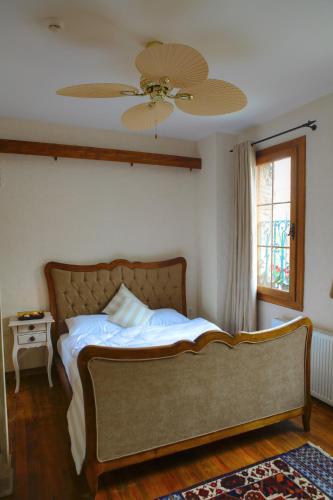 a bedroom with a bed with a ceiling fan at Ibri Hotel in Selcuk