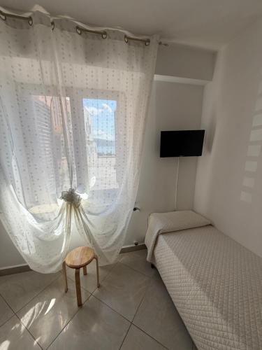 a small bedroom with a bed and a window at Il Cirismiro in Torre Faro