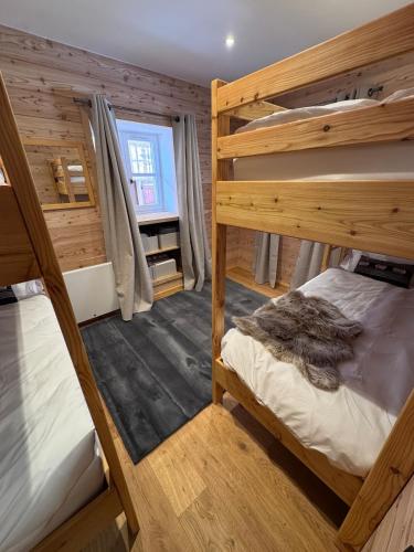 a room with two bunk beds and a window at Les Racines Chalet in Villard-Reculas
