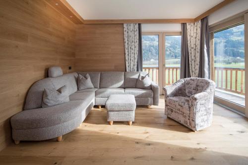 a living room with a couch and a chair at Alpinliving.Tirol in Aschau