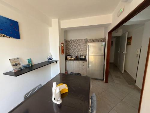 a dining room with a table and a kitchen at Il Cirismiro in Torre Faro