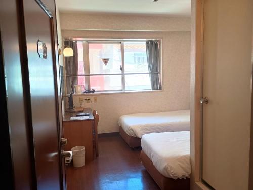 a small room with two beds and a window at Hotel-澄Sumi-波の上ビーチ徒歩5分 in Naha