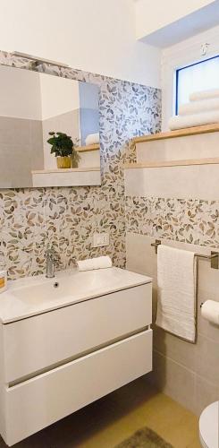 a white bathroom with a sink and a mirror at Regina Margherita in Crotone