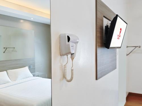 a hotel room with a phone and a bed at Red Planet Cagayan De Oro in Cagayan de Oro