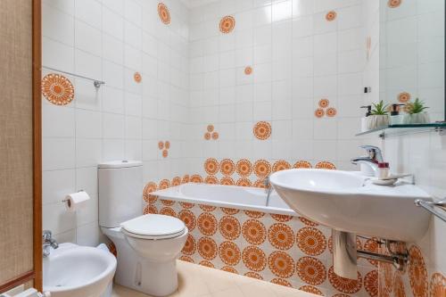 a bathroom with a sink and a tub and a toilet at Penthouse Magic View - Large penthouse in the center in Oristano