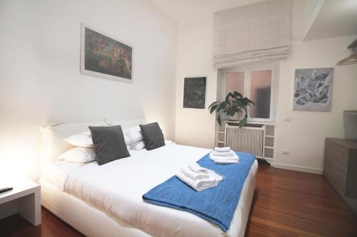 sypialnia z białym łóżkiem z niebieskim kocem w obiekcie Spanish Steps Art Apartment w Rzymie