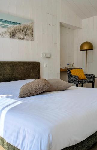 a large white bed in a room with a table at L'Ile sous le Vent in Sainte-Marie-de-Ré