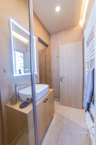 a bathroom with a sink and a mirror at Omega Suites 31 in Tríkala