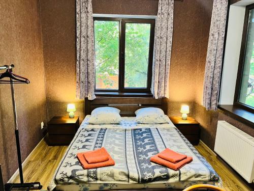 a bedroom with a bed with two orange pillows on it at Вілла Лісова комфорт in Skhidnitsa