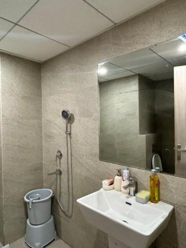 a bathroom with a sink and a shower and a mirror at Veloria Grand Suites in Greater Noida