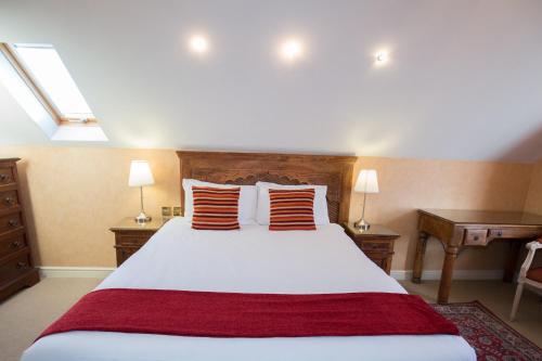a bedroom with a large white bed with red pillows at The Peacock Townhouse Hotel Kenilworth - Warwick in Kenilworth