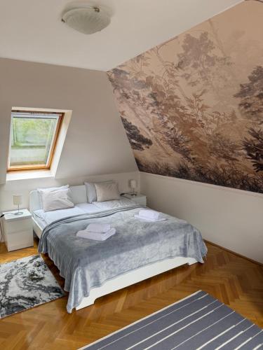 a bedroom with two beds and a painting on the wall at Kozmáry Vendégház in Matrafured