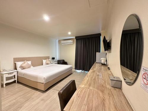 a hotel room with a bed and a mirror at Rattana View in Phitsanulok