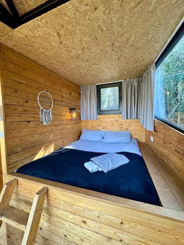 a bedroom with a bed in a log cabin at MONKEY MANSION - Luxury Treehouse - Private Escape with outdoor hot Tub in Abū Mīzān