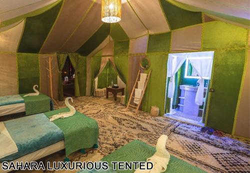 a room with two beds and a room with a room at Sahara Luxurious Tented in Merzouga