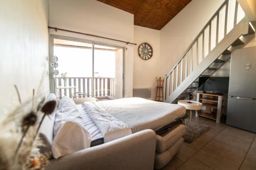 a bedroom with a bed and a large window at Le Donjon - Agréable T2 centre ville - parking gratuit 2 min - in Mont-de-Marsan