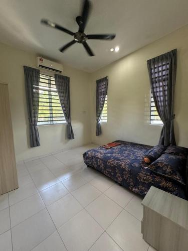 a bedroom with a bed and a ceiling fan at De Chempedak Homestay in Kampong Jarak