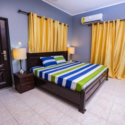 a bedroom with a bed and yellow curtains at Rapid City in Oshiyie