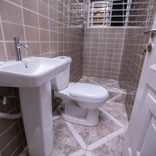 a bathroom with a toilet and a sink at Rapid City in Oshiyie