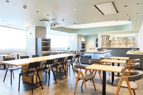 a restaurant with wooden tables and chairs at Heiwadai Hotel 5 in Fukuoka