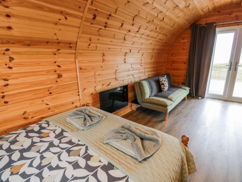 ein Schlafzimmer mit einem Bett und einem Stuhl in einem Zimmer in der Unterkunft Keith in Stranraer