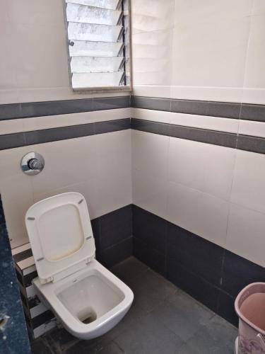 a bathroom with a white toilet in a room at Hotel Dipak in Himatnagar