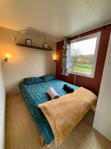 a bedroom with a large bed with a window at Camping les Portes du Perche in Mamers