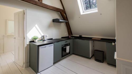 una cucina con un bancone nero e un lavello di T2 de la préfecture ad Arras