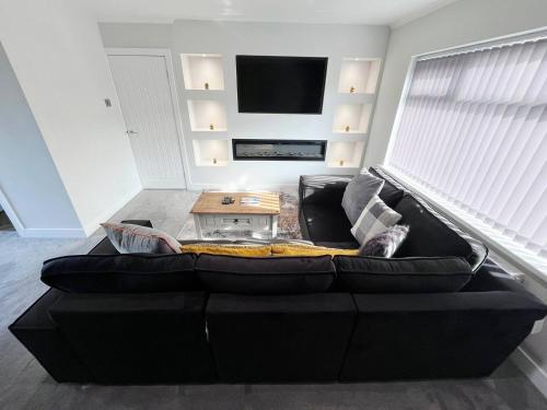 a black couch with a coffee table in a living room at Sea View House Marske-by-the-Sea - Coastal Stay - Pet Friendly in Marske-by-the-Sea