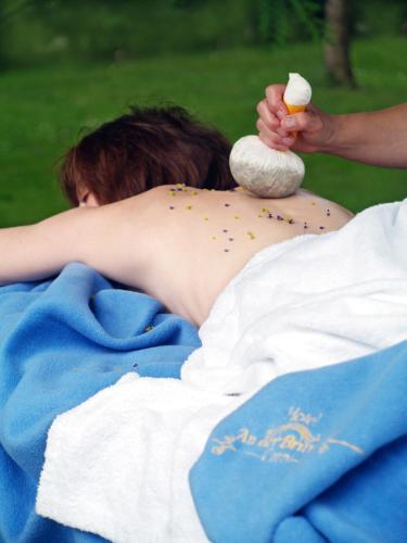 a woman laying on a bed with an egg on her back at Hotel An der Brunnader - Die Therme befindet sich 4 Geh-Minuten entfernt in Bad Birnbach