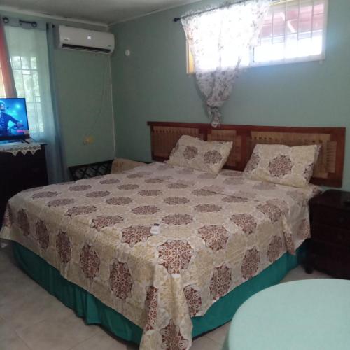 a bedroom with a bed with a quilt on it at Tambell Haven in Runaway Bay